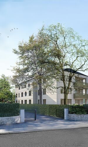 Mehrstöckiges Wohnhaus mit Balkonen, umgeben von Bäumen und Hecken, Einfahrt mit Tor und Straße im Vordergrund